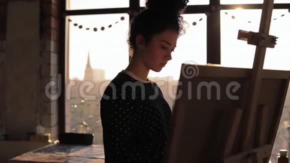 一位可爱的女艺术家在画架上画了20的慢镜头视频的预览图