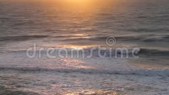 令人惊叹的日落在海滩上日落时海滩上的海水波浪阳光反射水面视频的预览图
