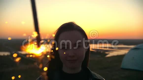 夏日夕阳下年轻女子带着星星点点站在山上的画像视频的预览图