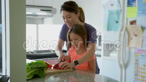 妈妈教女儿在厨房切菜4k视频的预览图