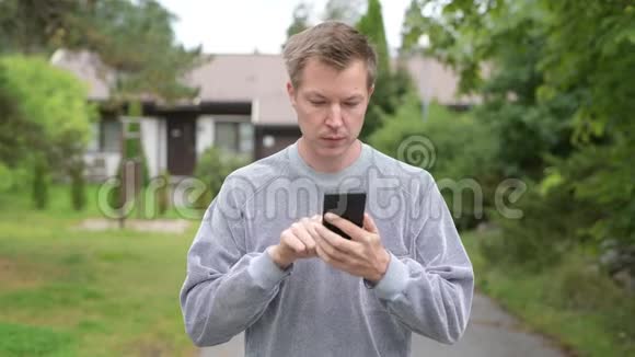 年轻快乐帅哥在户外家里用电话视频的预览图