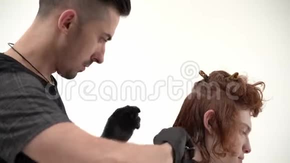 理发师使一个时尚的发型好男人长红色头发视频的预览图