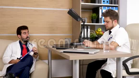 两个医生在办公室一个在教另一个视频的预览图