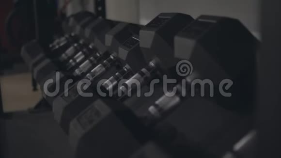 在一个现代化的体育健身房里一排排黑色哑铃运动和健身视频的预览图
