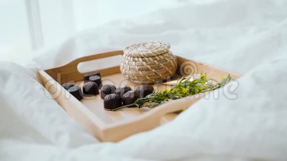 家中床上用品的浪漫早餐木制托盘床上有果汁和糖果视频的预览图