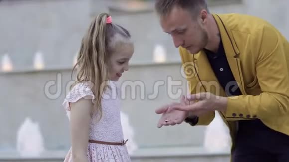 魔术师给小女孩表演硬币戏法视频的预览图