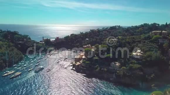 意大利的波尔图菲诺船只在夏季阳光明媚的日子穿过靠近沿海城镇的海峡空中景观视频的预览图