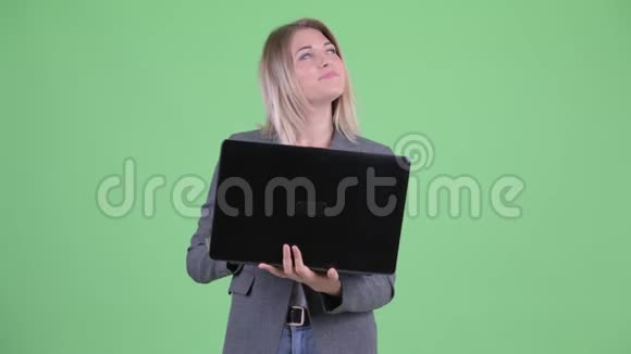 年轻的金发碧眼的女商人在用笔记本电脑思考视频的预览图
