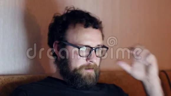 一个留着胡子和眼镜的人在家里的电脑里工作远程工作的概念视频的预览图
