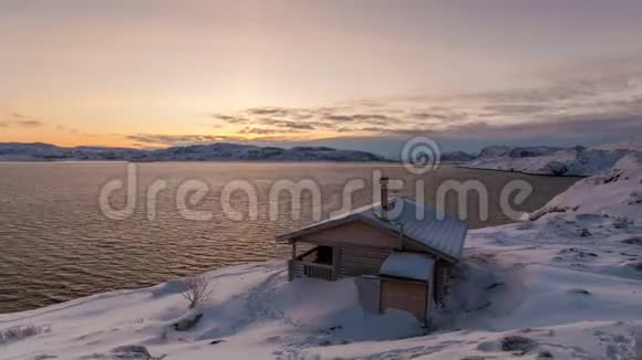 冬天黎明时分北冰洋海岸的小屋视频的预览图