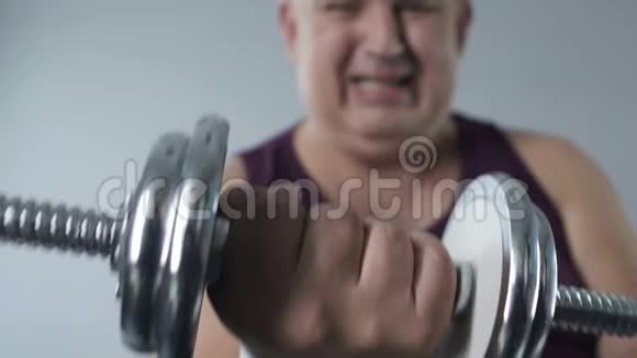 肥胖人士举哑铃特写镜头减肥锻炼视频的预览图