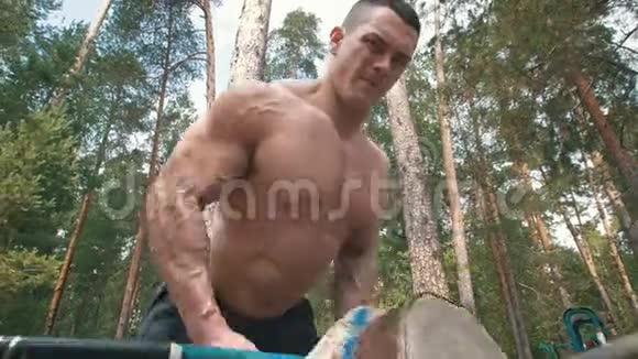 充气的肌肉男在森林里拿起巨大的沉重的水壶铃视频的预览图