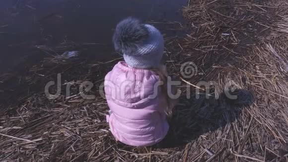小女孩在春天的湖边享受晴天视频的预览图