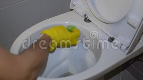 一名家庭佣工用黄色手套中的家用化学品清洁厕所视频的预览图