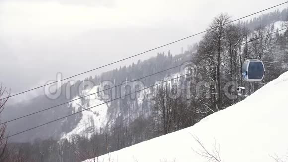 冬季景观有山坡被雪树覆盖有活动小屋滑雪场艺术滑雪视频的预览图