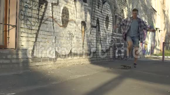 有活力的年轻人在街头涂鸦墙附近骑滑板爱好视频的预览图