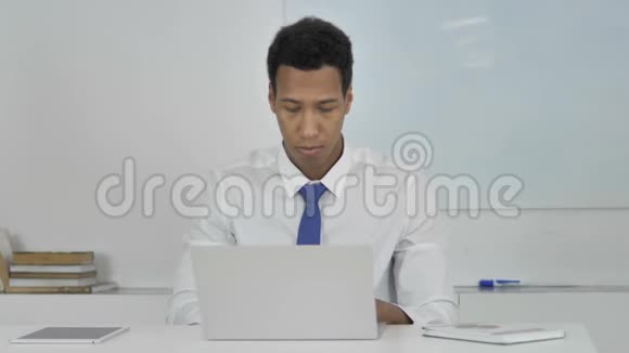 非裔美国商人在笔记本电脑上工作正面观点视频的预览图