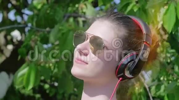 戴着耳机的漂亮少女喜欢音乐视频的预览图