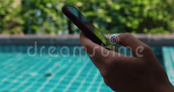 在游泳池附近使用智能手机视频的预览图