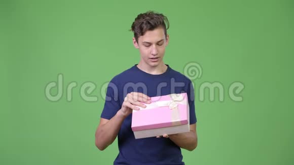 年轻英俊少年打开礼品盒视频的预览图