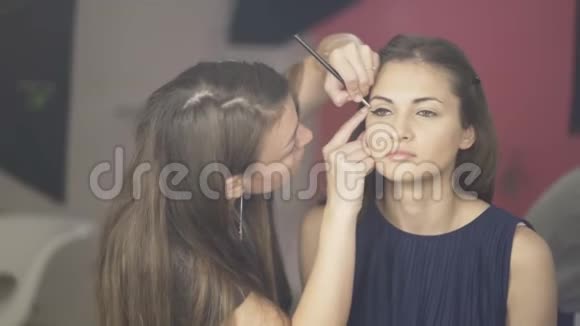 化妆师在模特的脸上涂上化妆霜视频的预览图