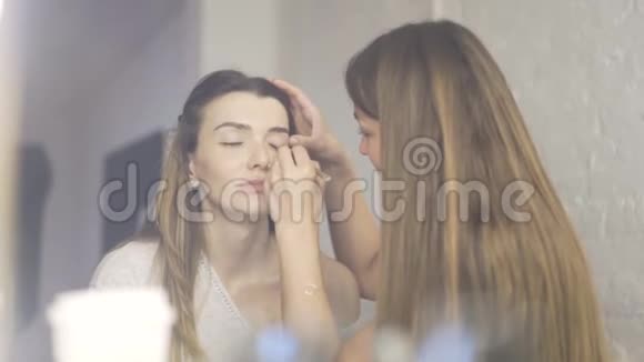 专业化妆师将化妆膏涂在漂亮模特的眼皮上视频的预览图