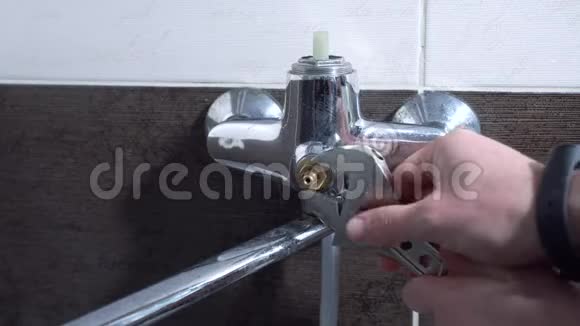 这个人修理浴室里的水龙头更换车轴特写视频的预览图