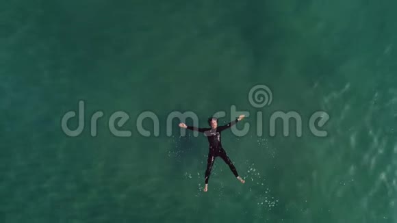 穿着潜水衣的人在水面上放松视频的预览图
