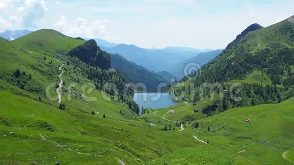 意大利阿尔卑斯山意大利春天的绿色草地牧场和人工湖视频的预览图