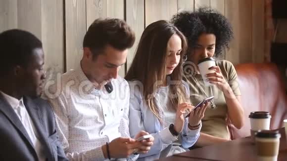 使用智能手机和咖啡厅聊天的多种族朋友手机成瘾视频的预览图