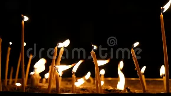 黑暗背景下教堂内蜡蜡烛燃烧慢动作视频的预览图