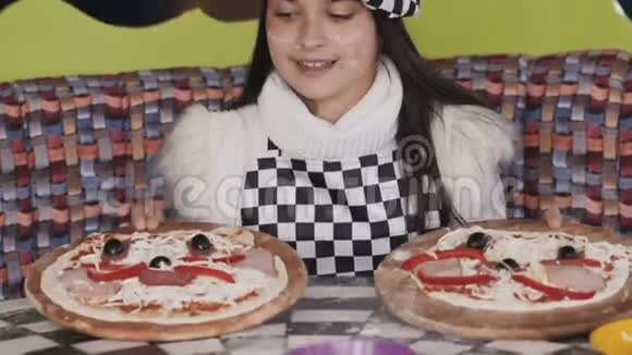 小女孩在镜头前展示了两个比萨饼慢慢地视频的预览图