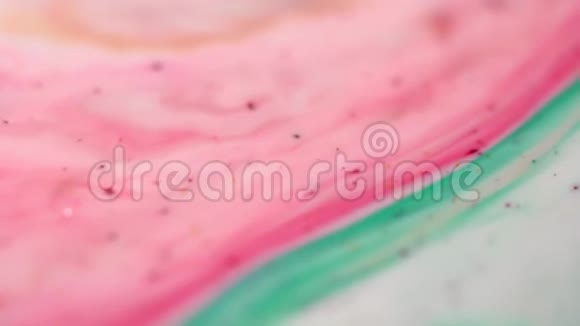 在乳白色的表面上特写五颜六色的粉红色和绿色模糊的油漆污渍色彩斑斓的背景视频的预览图