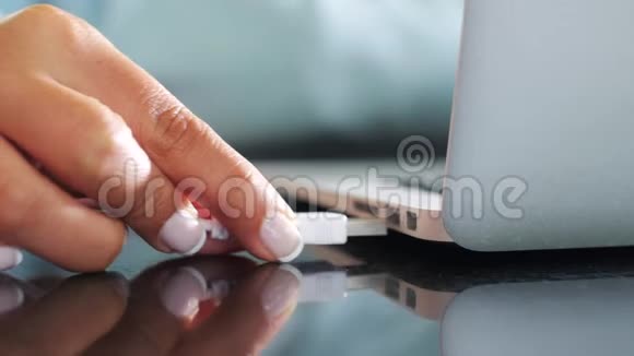 将usb驱动线插入笔记本电脑并输入电脑的女性手部特写视频的预览图