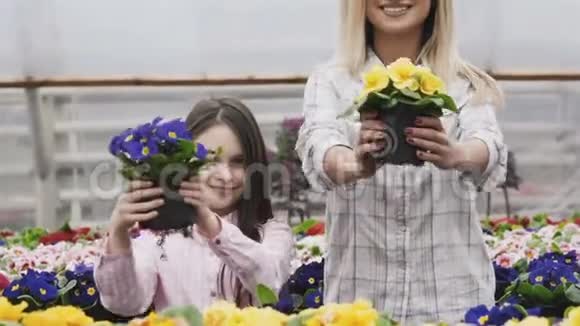 微笑的成人和年轻女孩将花盆拉伸成相机的肖像视频的预览图