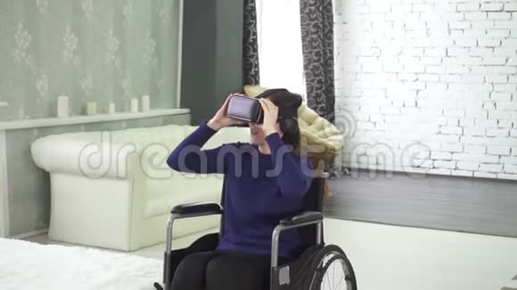 轮椅上的年轻残疾妇女使用虚拟现实头盔3D技术视频的预览图