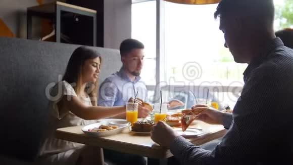两个朋友在咖啡馆里讲故事吃早餐披萨果汁甜点视频的预览图
