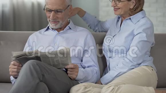 老人看报纸女人搂着他的肩膀温柔视频的预览图