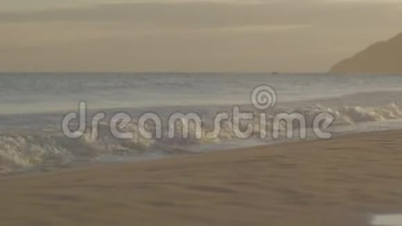一对成熟的夫妇手牵着手在沙滩上漫步视频的预览图