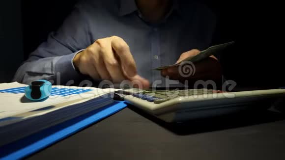 计算美元钞票和使用计算器的人办公室的贷款视频的预览图