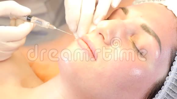 美容诊所的概念美容师动手制作肉毒杆菌注射到女性嘴唇年轻女子的面部表情视频的预览图
