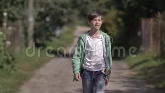 口袋里有弹弓的男孩在户外乡间小路上散步视频的预览图