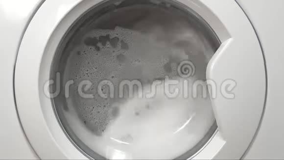 衣服在洗衣机里用大量的泡沫清洗在洗衣房里每天用洗衣机清洗视频的预览图