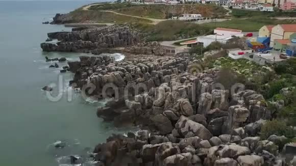 从空中拍摄到俯瞰岩石海岸和葡萄牙佩尼切房屋的美丽景色4k动态质量视频的预览图