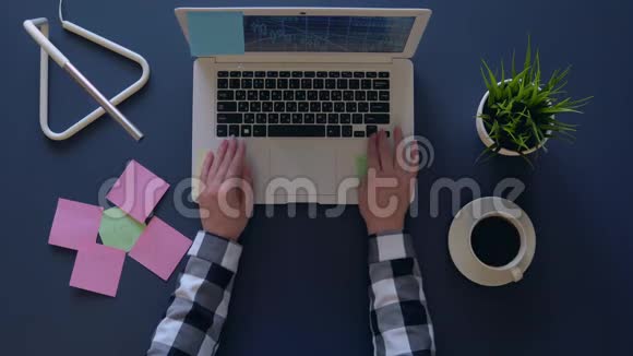 商务女性坐在桌子旁喝咖啡时在笔记本电脑上工作空中射击视频的预览图