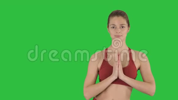 年轻女子做瑜伽运动在绿色的屏幕上色度键视频的预览图