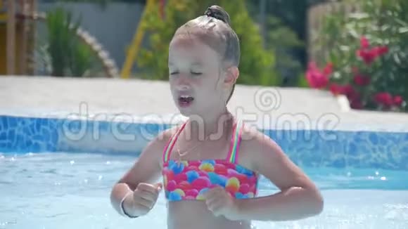 快乐的小女孩在炎热的夏天在室外游泳池玩耍孩子们学游泳儿童在热带玩耍视频的预览图