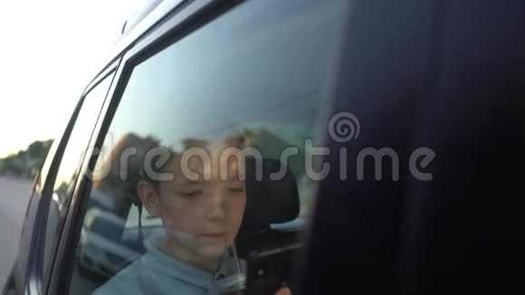 青少年晚上在汽车后座上用手机视频的预览图