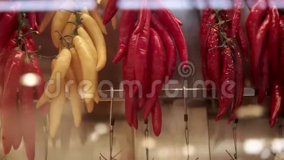 不同种类的辣辣椒在市场上挂在墙上特写视频的预览图