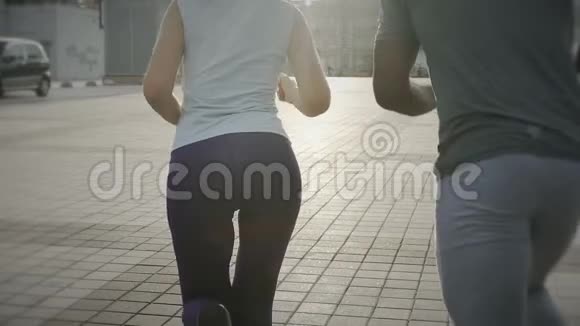 在城市广场跑步的情侣透视镜头优雅的慢动作慢跑视频的预览图